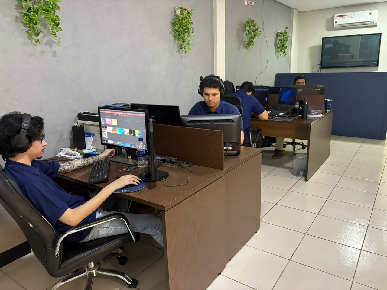 Time técnico da Unânime trabalhando em computadores ao redor da mesa de atendimento
